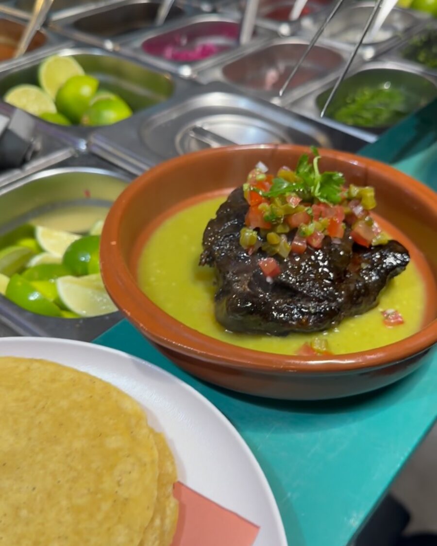 Beef cheeks in salsa verde beside the salsa bar and fresh tortillas